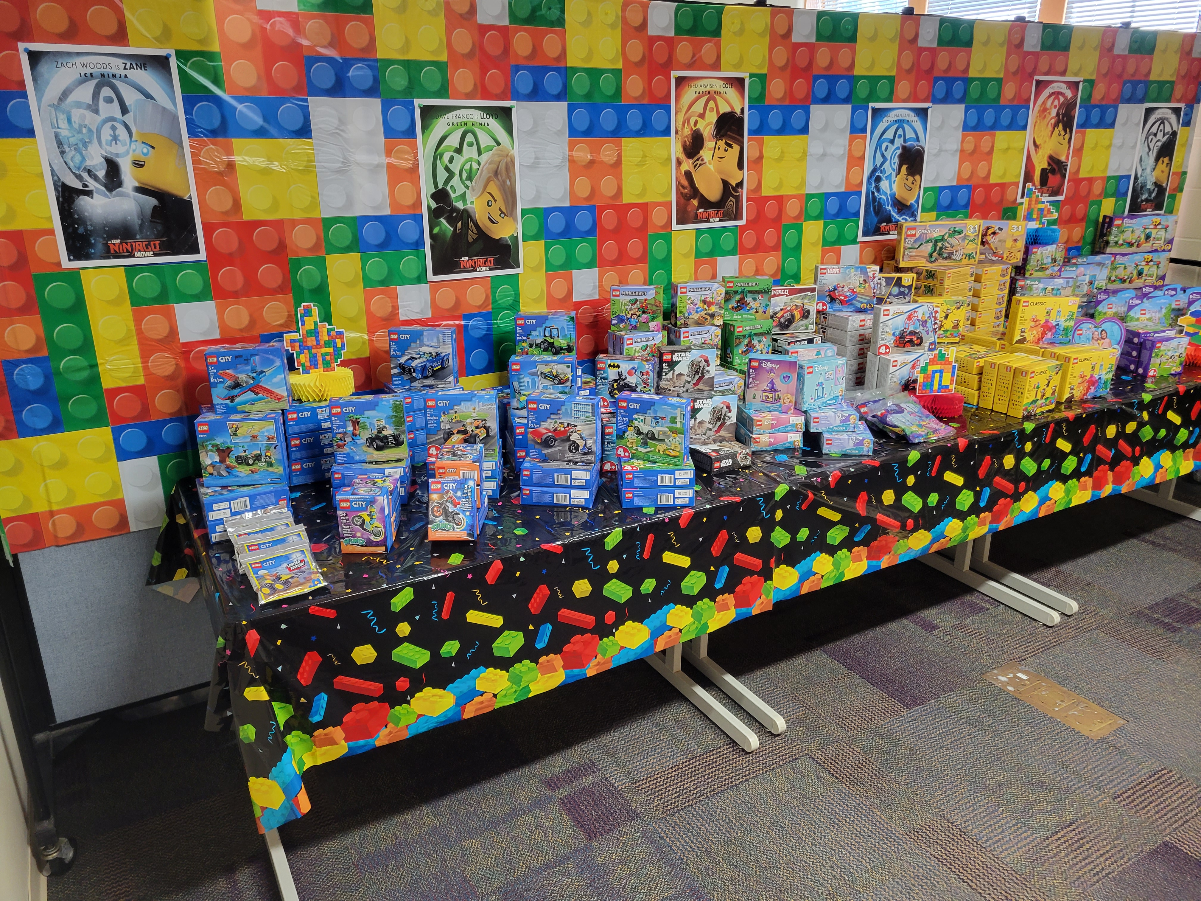 table decorated with LEGO kits and posters of the LEGO Ninjago movie