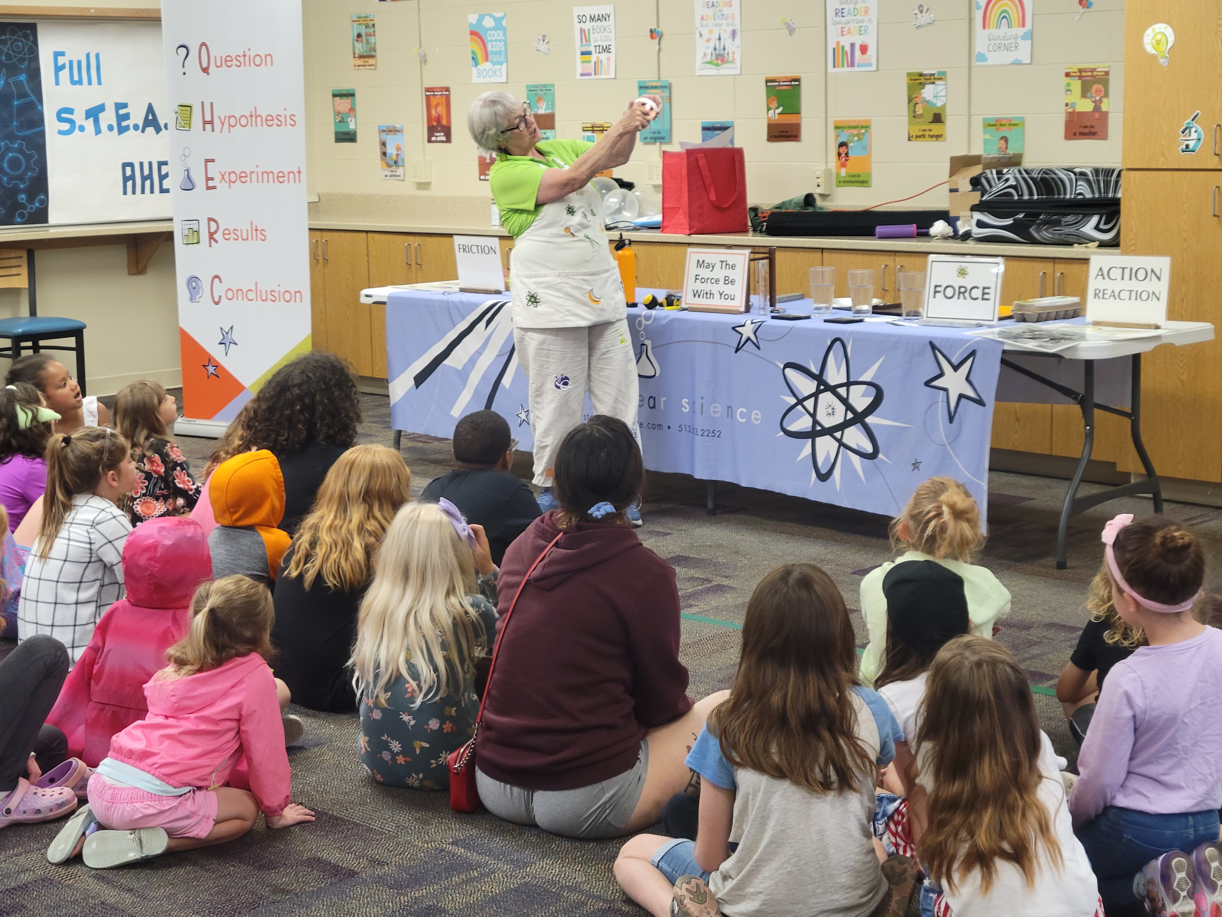 science performer at the front of a crowd of children