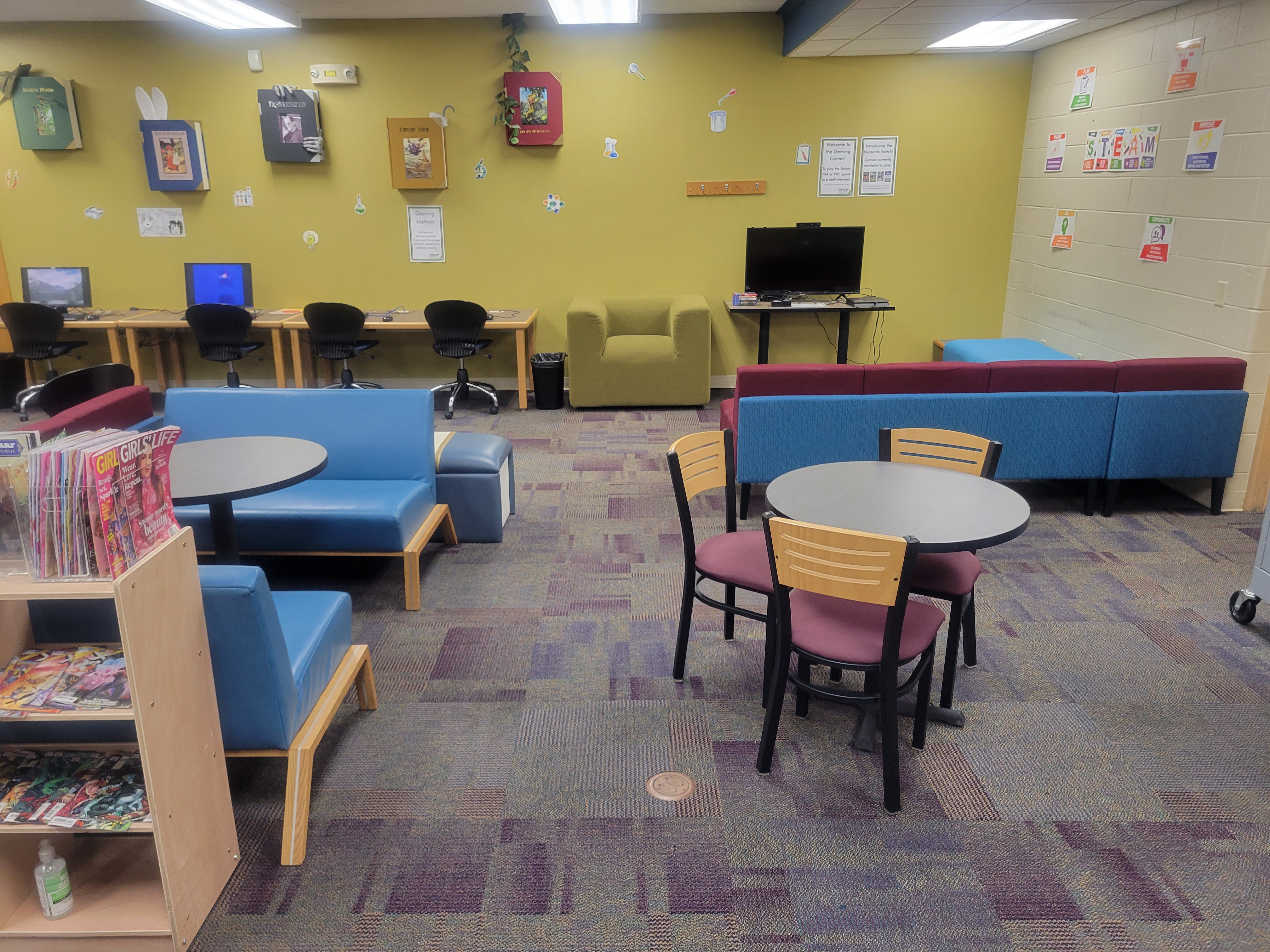 Photo of the teen area that includes computers, couches and the gaming tv